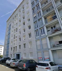 a large building with cars parked in front of it at L'Atelier Eiffel Moderne & confortable in Saint-Brieuc