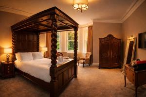 a bedroom with a large canopy bed and a window at Friars Carse Country House Hotel in Dumfries +43 photos