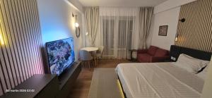 a hotel room with a bed and a flat screen tv at Sunset Beach Studio by Blaxy Resort Olimp in Olimp