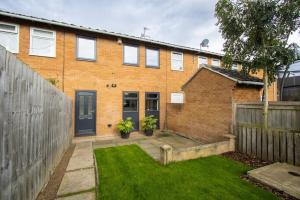 a brick house with a fence and a yard at Charming three bedroom house in Durham in Brandon
