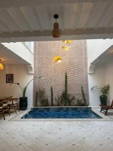 a pool in the middle of a room with a wall at Riad Reflet D'orient Marrakech in Marrakesh