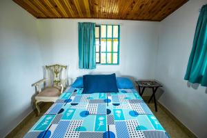 a bedroom with a blue and white bed with a window at Finca La Molienda, espléndido Mirador del Quindio in Circasia