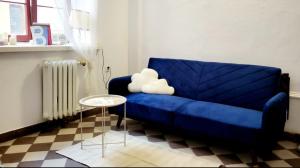 ein blaues Sofa in einem Wohnzimmer mit einem Tisch in der Unterkunft Niebo in Lublin + 4 Fotos
