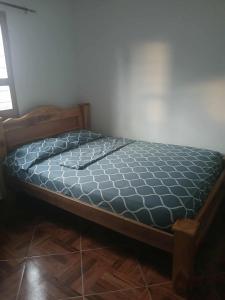 a bed with a wooden frame in a room at Casa madrigueña rincón del mar in Rincón +3 photos