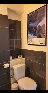 a bathroom with a toilet and a painting on the wall at Niebo in Lublin