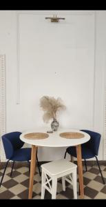 a white table with two chairs and a plant on it at Niebo in Lublin