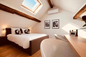 a bedroom with a bed and a desk with a chair at DEUXHOMMES Boutique B&B Massage&Spa in Hasselt