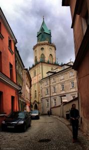 a person standing in front of a building with a clock tower at Niebo in Lublin