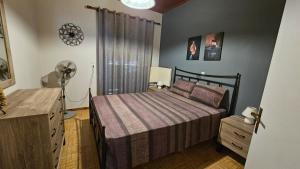 a bedroom with a bed and a dresser and a fan at Raptis House in Karavostamo +25 photos