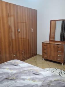 a bedroom with a bed and a dresser and a mirror at Elegant Apartment City Center in Fier