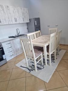 a white table and four chairs in a kitchen at Elegant Apartment City Center in Fier