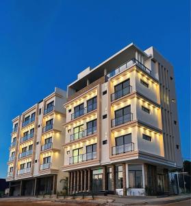 a tall white building with lights on at Paraná Beach Apart Hotel in Encarnación