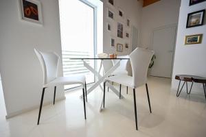 a dining room with a glass table and white chairs at Villa OLIVA in Kľačany