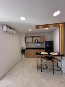 a kitchen with a table and chairs in a room at Paraná Beach Apart Hotel in Encarnación