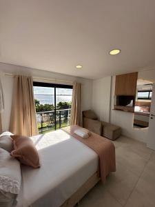 a bedroom with a large bed and a large window at Paraná Beach Apart Hotel in Encarnación +18 photos