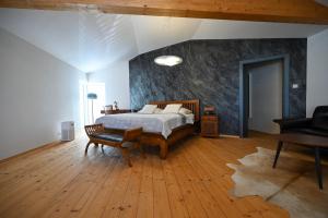 a bedroom with a bed and a wooden floor at Villa OLIVA in Kľačany