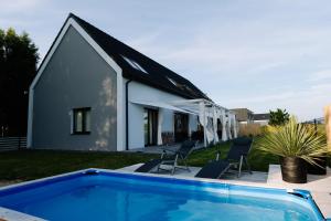 a house with a swimming pool next to a building at 4 Pory Roku in Darłowo