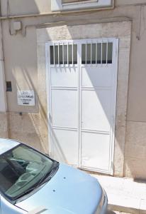a white garage door on the side of a building at Beb lungo tiflis matrimoniale, quadrupla in Bitonto