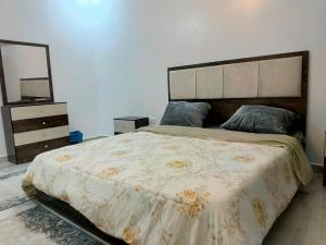 a bedroom with a large bed and a mirror at شقق العون in Jerash