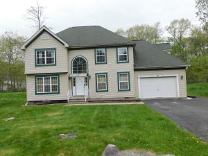 a white house with a garage in a yard at Beautiful Colonial in the Poconos in Tobyhanna