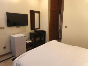 a bedroom with a bed and a television on the wall at The Aristocrat Residency in Islamabad