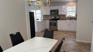 a kitchen with white cabinets and a white table and chairs at Beautiful Colonial in the Poconos in Tobyhanna