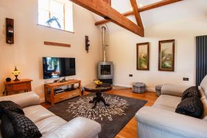 a living room with a couch and a tv at Rivington Barn in Kerne Bridge