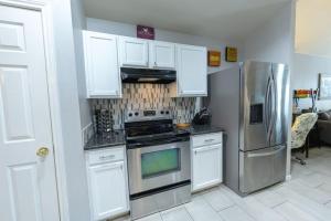 a kitchen with white cabinets and stainless steel appliances at Modern Updates - Great Location - King Bed- BMT in San Antonio +26 photos