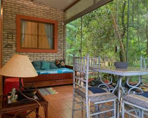 a porch with a bed and a table and chairs at Casitas del bosque in San Bernardino