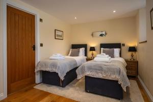a bedroom with two beds with towels on them at Rivington Barn in Kerne Bridge