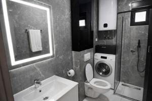 a bathroom with a sink toilet and a washing machine at Avis 1 in Igalo +10 photos