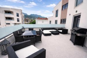 a balcony with chairs and tables and a grill at Avis 1 in Igalo