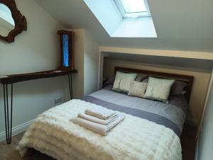 a bedroom with a bed with towels on it at The Travellers Retreat in Neston