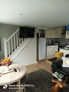 a living room with a couch and a kitchen at The Travellers Retreat in Neston +8 photos