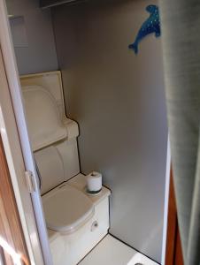 a small bathroom with a toilet with a roll of toilet paper at Cruzo The House Bus in Takaka