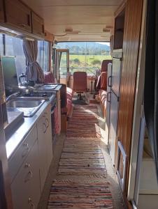 a kitchen in an rv with a view of a field at Cruzo The House Bus in Takaka