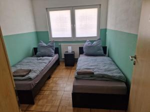 two beds in a room with a window at Wolfskraft in Hauenstein