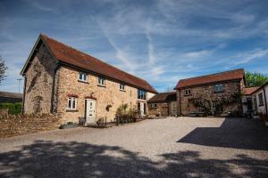 a large brick building with a driveway in front of it at Rivington Barn in Kerne Bridge
