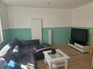 a living room with a couch and a flat screen tv at Wolfskraft in Hauenstein