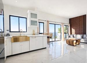 a kitchen with a sink and a living room at Hillzone View in Kingston