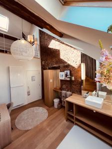 a bathroom with a sink and a brick wall at DEUXHOMMES Boutique B&B Massage&Spa in Hasselt