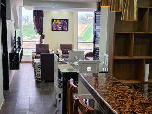 a room with a kitchen with a counter and chairs at Torres buambiles 2 in Ipiales