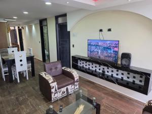 a living room with a chair and a tv on a wall at Torres buambiles 2 in Ipiales