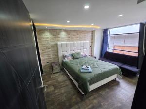 a bedroom with a large bed and a couch at Torres buambiles 2 in Ipiales