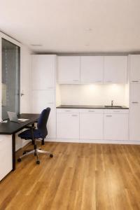 an office with a desk and a chair in a room at Modern Nature Apartment ! WIFI & Parking Free ! in Frauenfeld