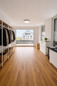 a large room with a hardwood floor and a large window at Modern Nature Apartment ! WIFI & Parking Free ! in Frauenfeld