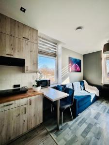 a living room with a blue couch and a table at Chopina Place in Oświęcim