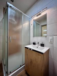 a bathroom with a sink and a shower at Chopina Place in Oświęcim +24 photos