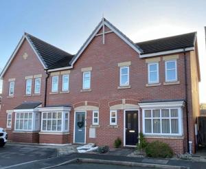 a red brick house with white windows at Golf Let in Southport