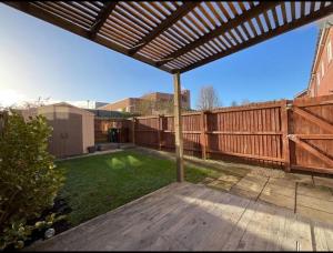 a backyard with a wooden deck and a wooden fence at Golf Let in Southport